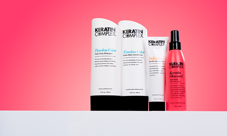 Keratin Complex products on a white countertop against red gradient background.