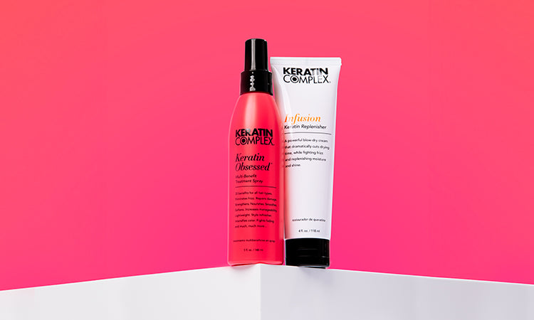 Keratin Complex Keratin Obsessed Multi-Benefit Spray and Infusion Keratin Replenisher placed on a white podium against a pink gradient background.