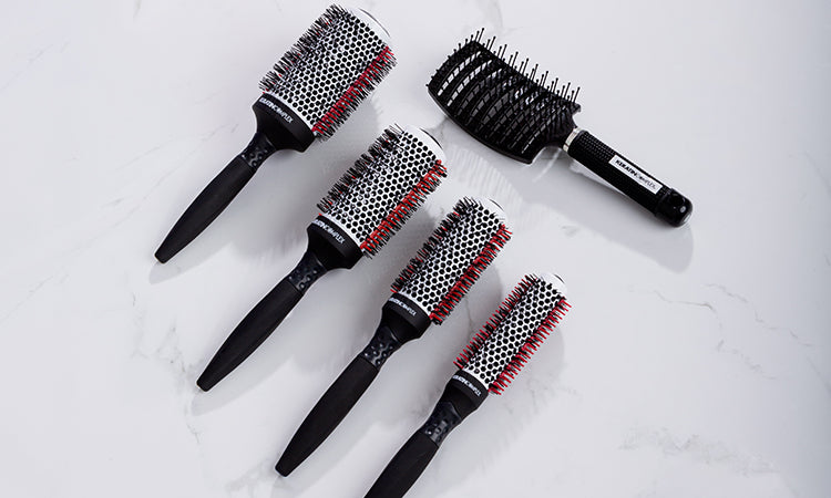 Keratin Complex brushes placed on a white marble surface.
