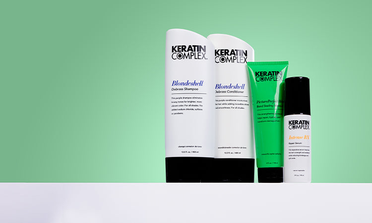 Keratin Complex hair care product displayed on a white countertop with a green background.