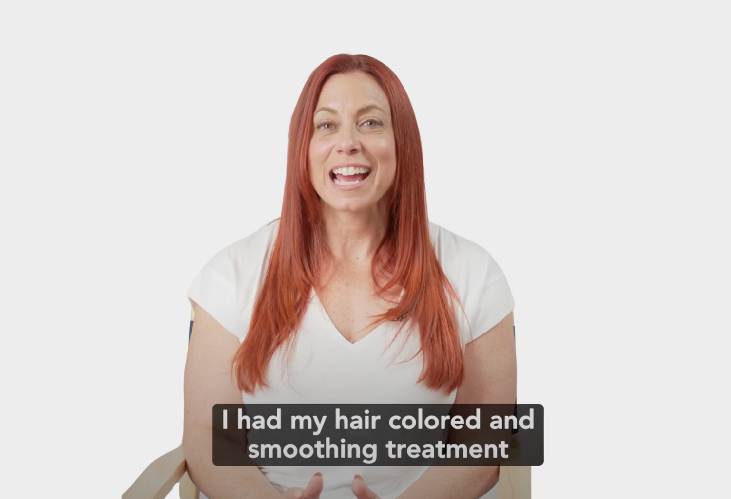 Woman with red hair wearing a white shirt on a plain background