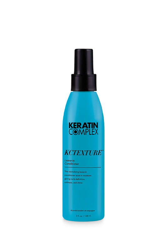 A blue bottle of Keratin Complex KCTEXTURE Leave-In Conditioner 5 oz. on a clear background.