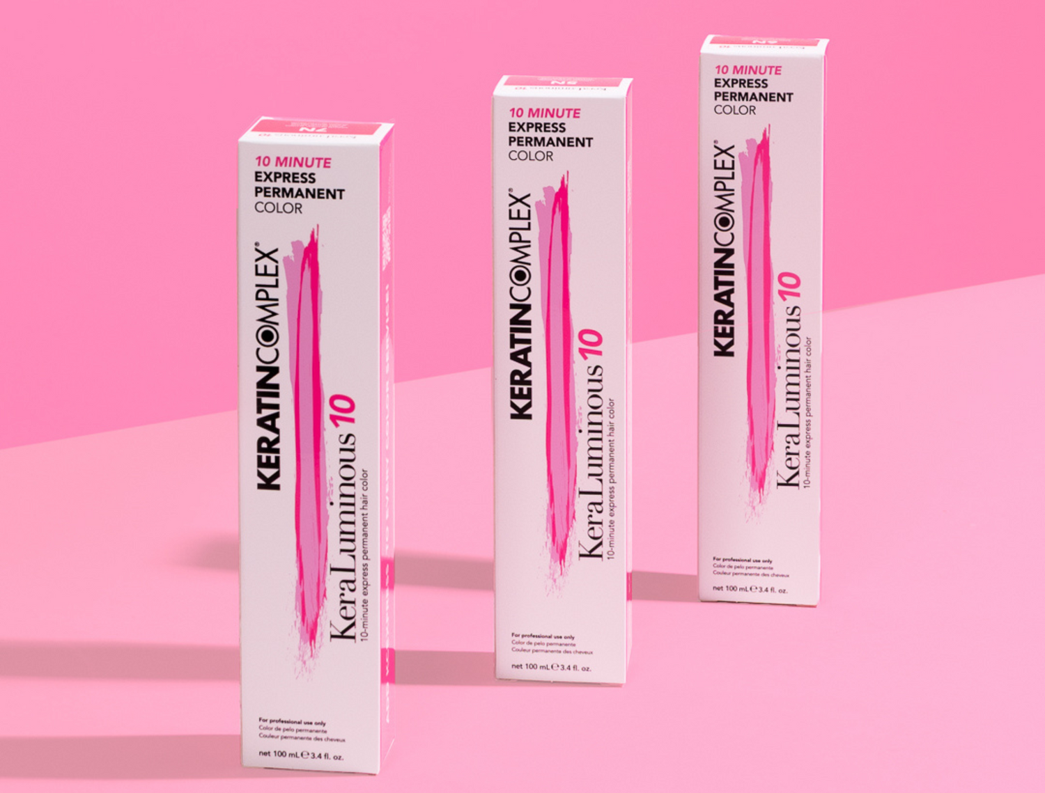Keratin Complex color packaging on a pink background.
