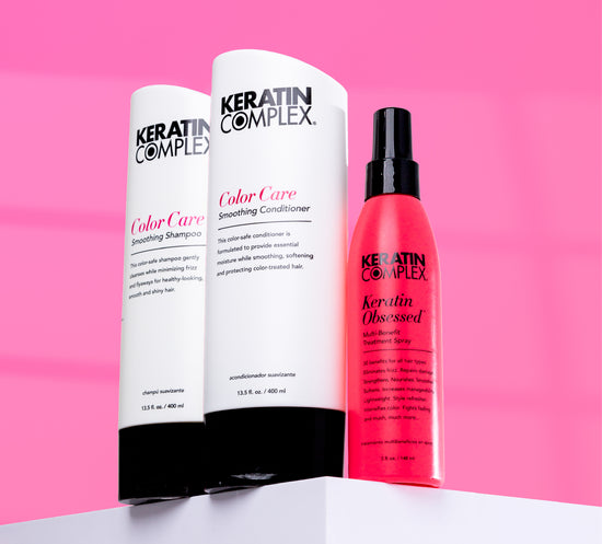 Three Keratin Complex products are displayed against a pink background: Color Care Smoothing Shampoo, Color Care Smoothing Conditioner, and Keratin Obsessed Multi-Benefit Treatment Spray.