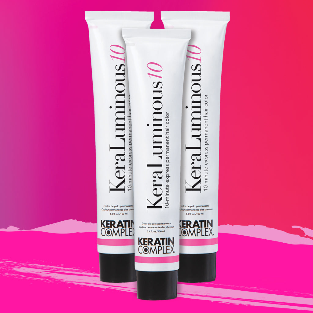 Three tubes of KeraLuminous hair color on a pink background