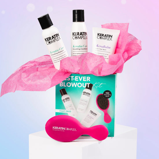 Best Ever Blow Dry Kit set against a soft holiday-themed background with pink and purple hues and snow-like dots.