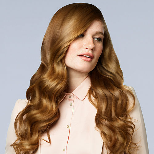 A closeup of a woman who has long curly red hair